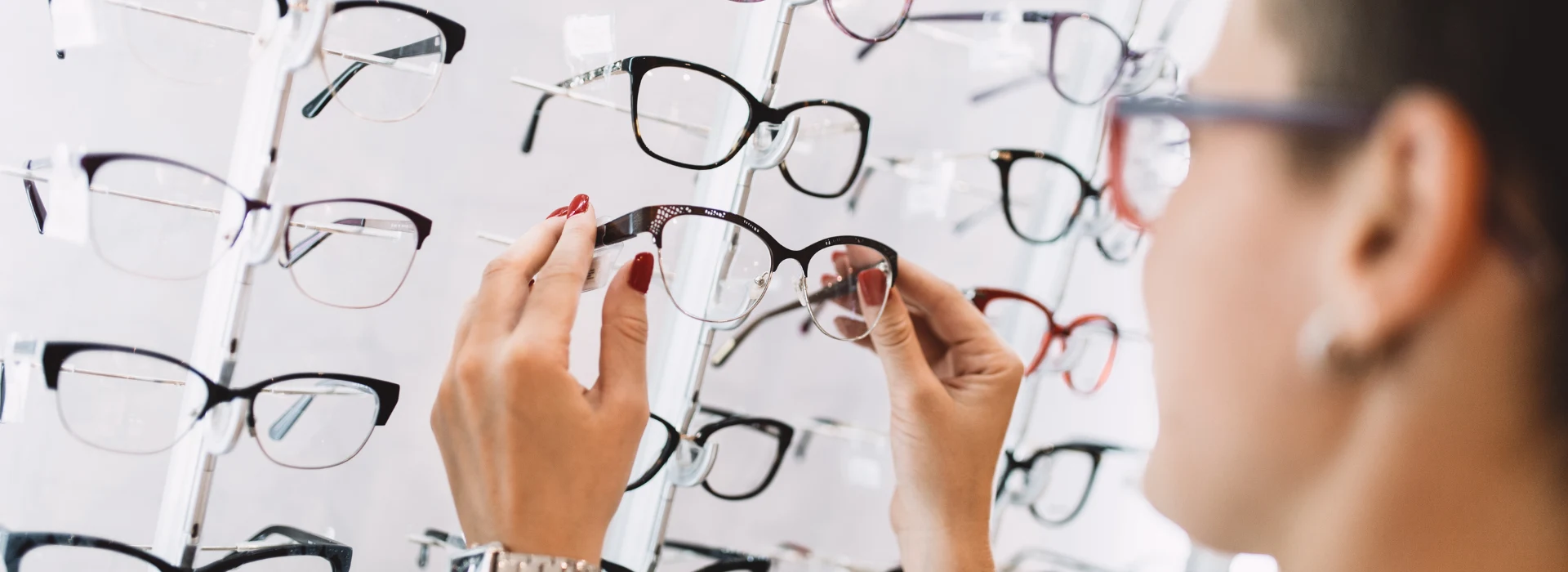 Sieviete Dr.Lensor optikas interneta veikalā izvēlas brilles no stenda